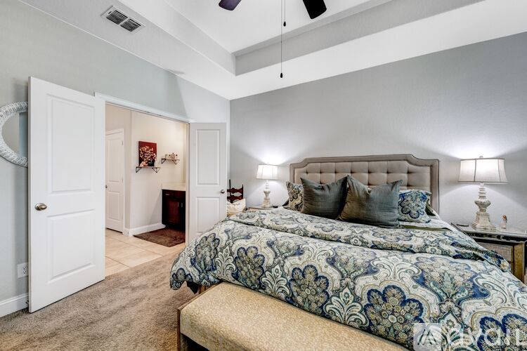 A bedroom with a large bed and a fireplace.