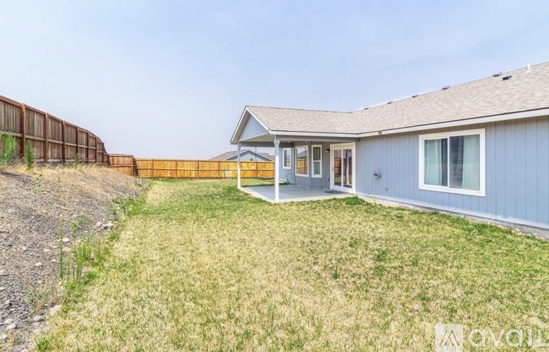A house with a blue exterior and a brown fence.