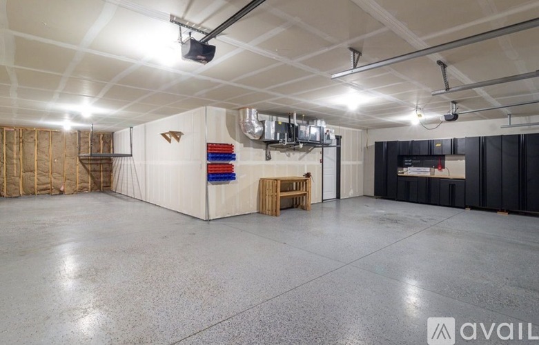 A spacious room with a white ceiling, a black wall, and a wooden table.