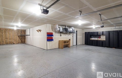 A spacious room with a white ceiling, a black wall, and a wooden table.