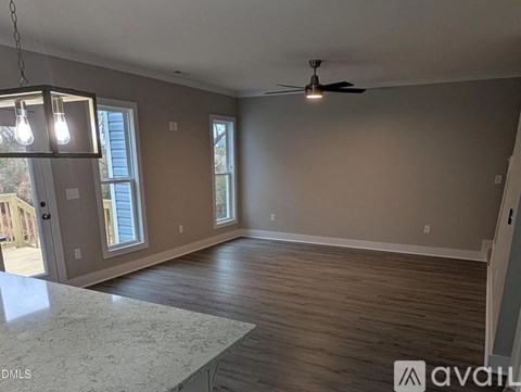 A room with a ceiling fan and a light bulb hanging from the ceiling.