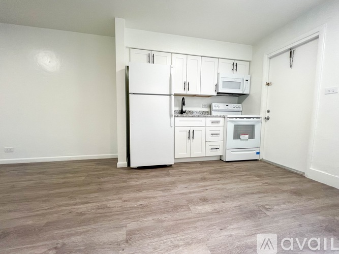A kitchen with white appliances and cabinets is available for rent.