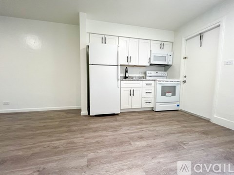 A kitchen with white appliances and cabinets is available for rent.