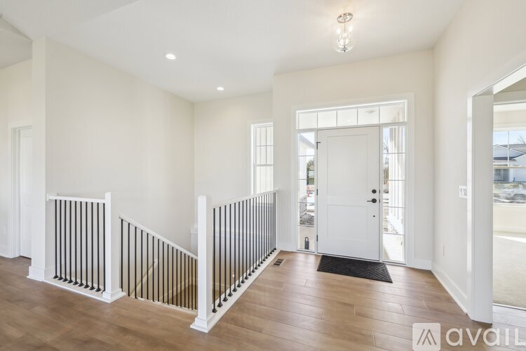 A spacious room with wooden floors and white walls.