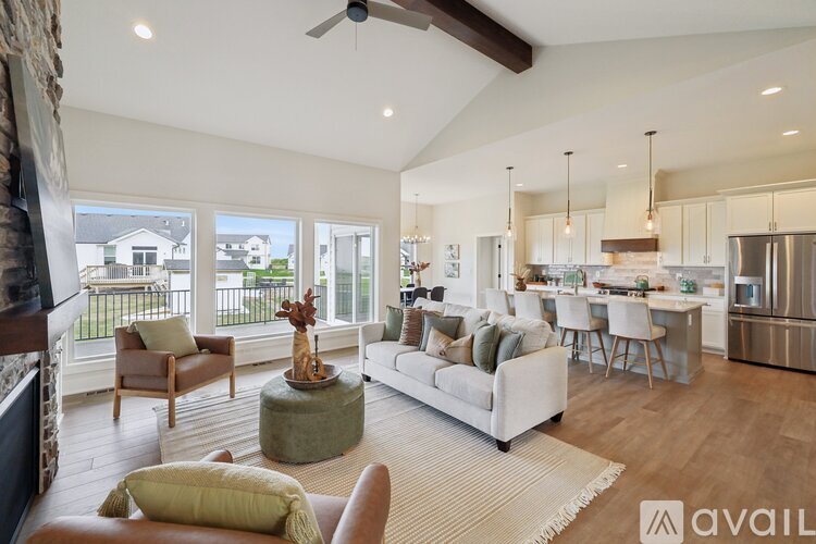 A spacious living room with a fireplace and a large window overlooking a balcony.