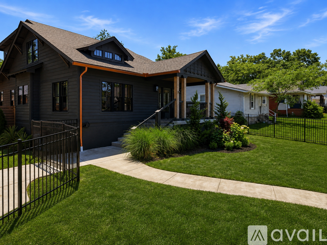 A house with a black fence and a green lawn.