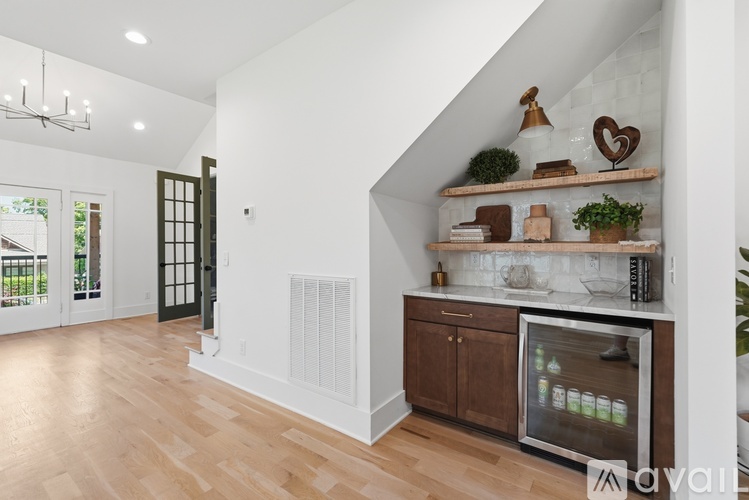 A kitchen with wooden floors and a white wall.
