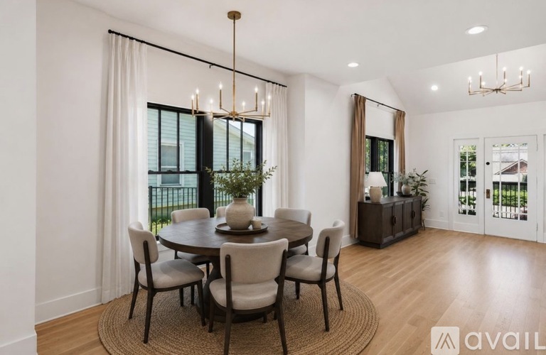 A dining room with a round table and chairs.