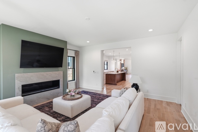 A living room with a white couch and a fireplace.