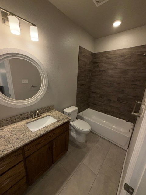 A bathroom with a sink, toilet, and bathtub.