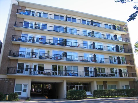 Apartment building with balconies and a garage entrance.