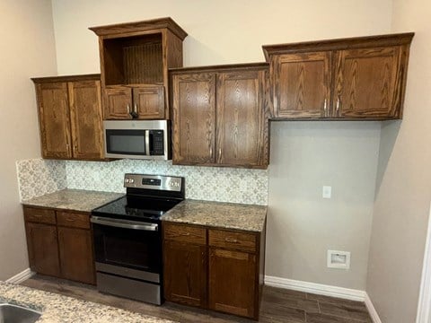 A kitchen with wooden cabinets and granite countertops.