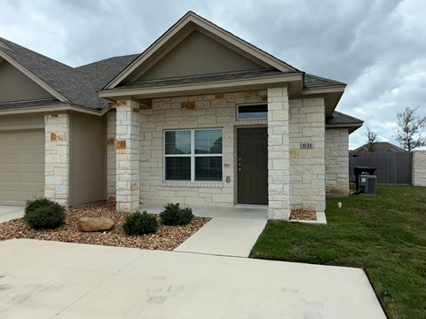 A house with a grey roof and a brown door.