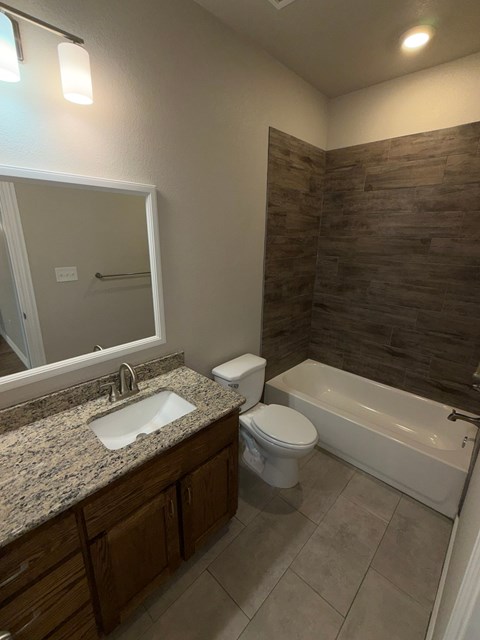 A bathroom with a sink, toilet, and bathtub.