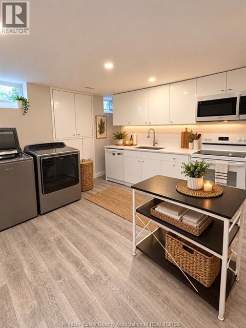 A kitchen with white cabinets and a black table.