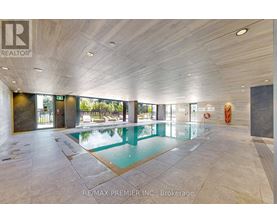 A large indoor swimming pool with a tiled floor and a ceiling with wooden panels.