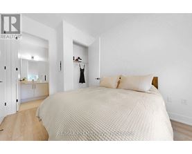 A bedroom with a large bed and a dresser in the background.