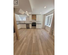 A kitchen with wooden floors and white cabinets.