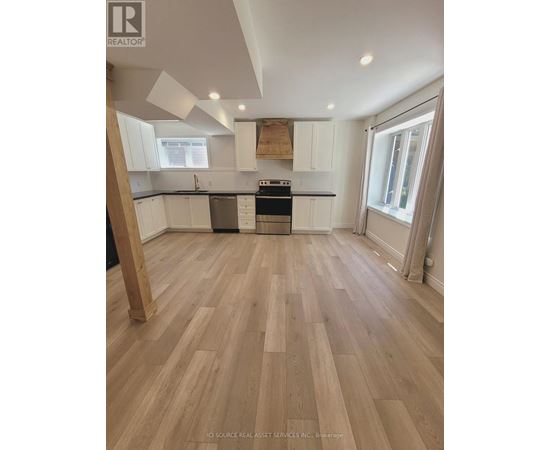 A kitchen with wooden floors and white cabinets.