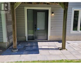 A grey door is in the middle of a concrete walkway.