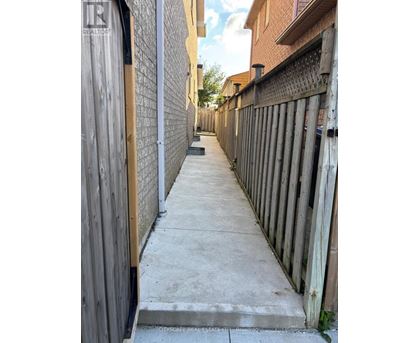 A narrow alley with wooden fences on both sides.