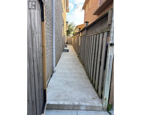 A narrow alley with wooden fences on both sides.