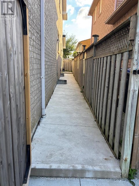 A narrow alley with wooden fences on both sides.