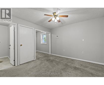 A room with a ceiling fan and a window.