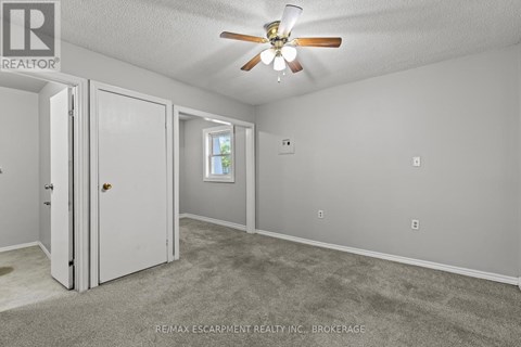 A room with a ceiling fan and a window.