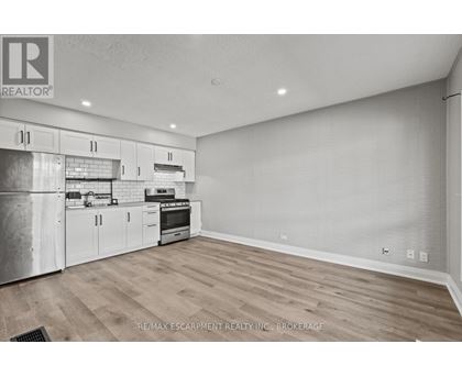A kitchen with white cabinets and a stainless steel refrigerator.