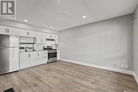 A kitchen with white cabinets and a stainless steel refrigerator.