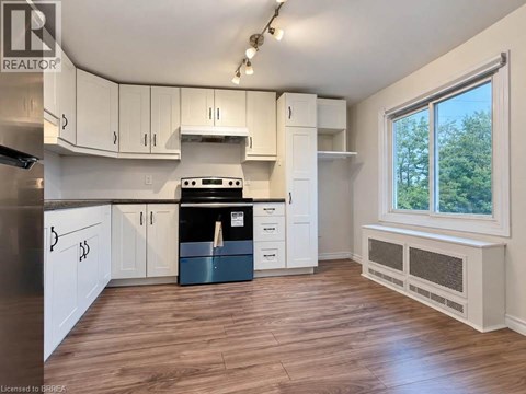 A kitchen with white cabinets and a black stove top oven.