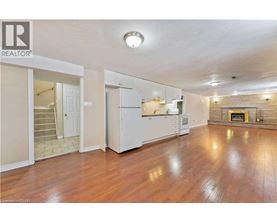 A spacious living room with hardwood floors and a fireplace.