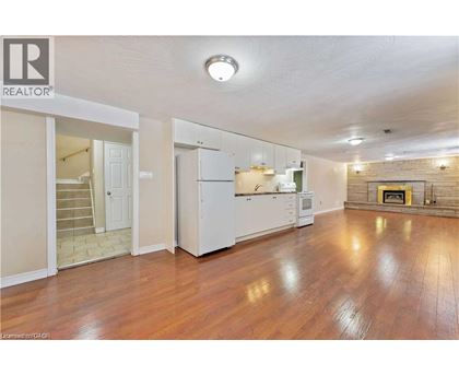 A spacious living room with hardwood floors and a fireplace.