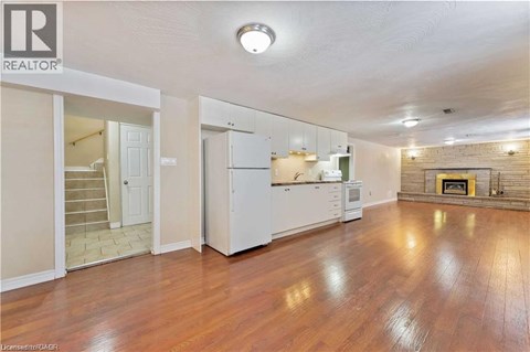 A spacious living room with hardwood floors and a fireplace.