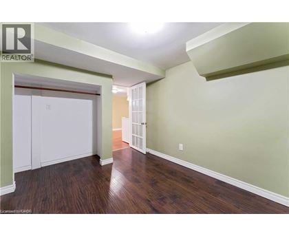 A room with wood flooring and a white closet.
