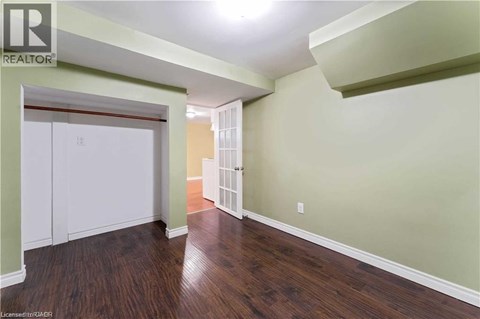 A room with wood flooring and a white closet.