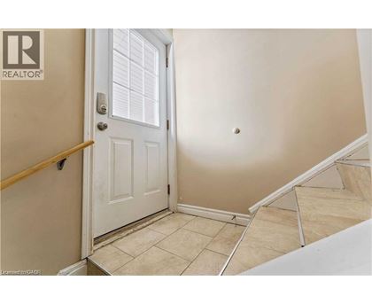 A white door is in a room with a tan wall.