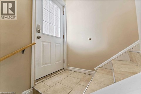 A white door is in a room with a tan wall.