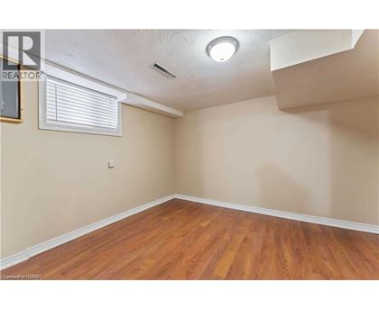 A room with wooden flooring and a window with blinds.