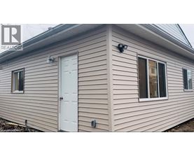 A house with a white door and windows is for sale.