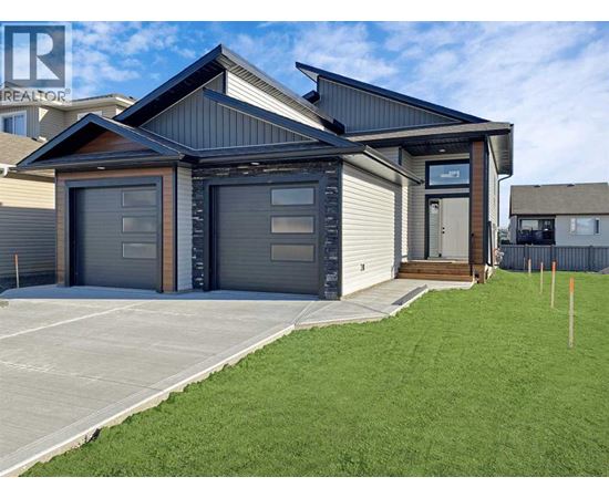A modern house with a grey garage door is for sale.