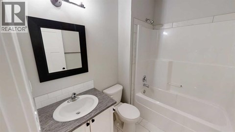 A bathroom with a sink, toilet, and bathtub.