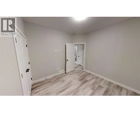 A room with a white door and a white cabinet with a black handle.