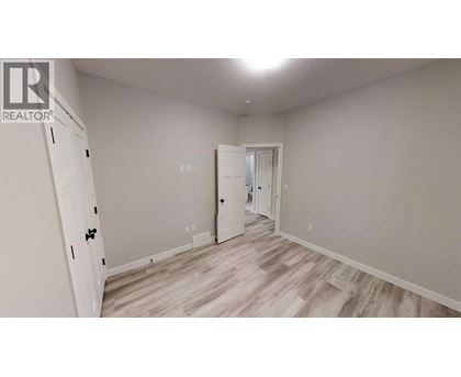A room with a white door and a white cabinet with a black handle.