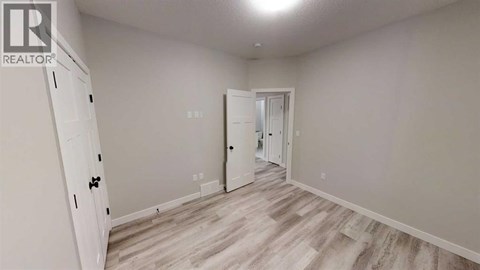 A room with a white door and a white cabinet with a black handle.
