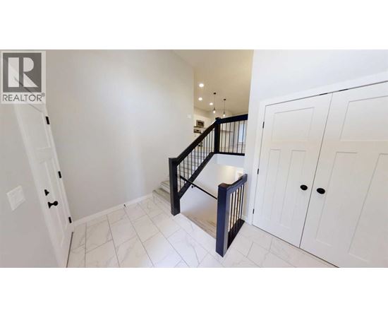 A white hallway with a black staircase and white cabinets.