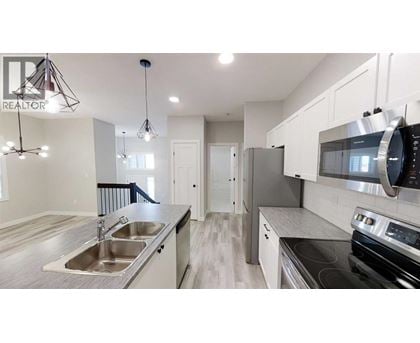 A modern kitchen with a stainless steel refrigerator and oven.