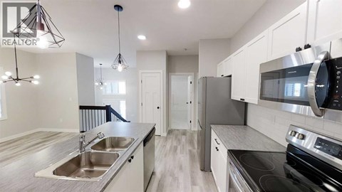 A modern kitchen with a stainless steel refrigerator and oven.