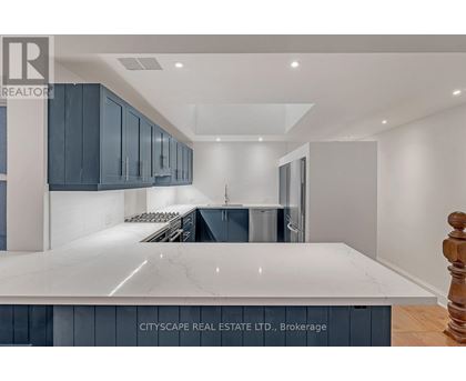 A modern kitchen with dark blue cabinets and a white marble countertop.